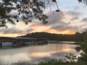 A scenic view of a lake with a boat dock at sunset